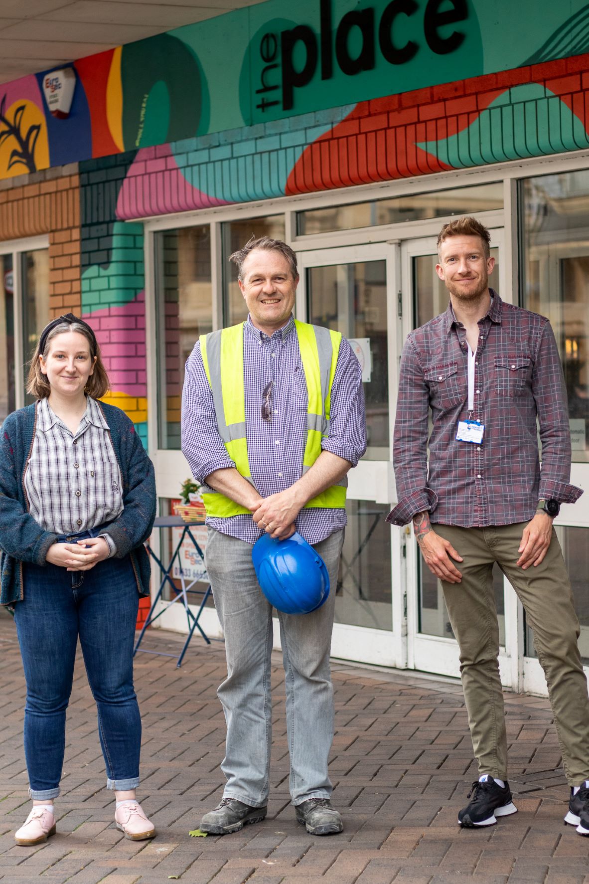 three people stood outside building