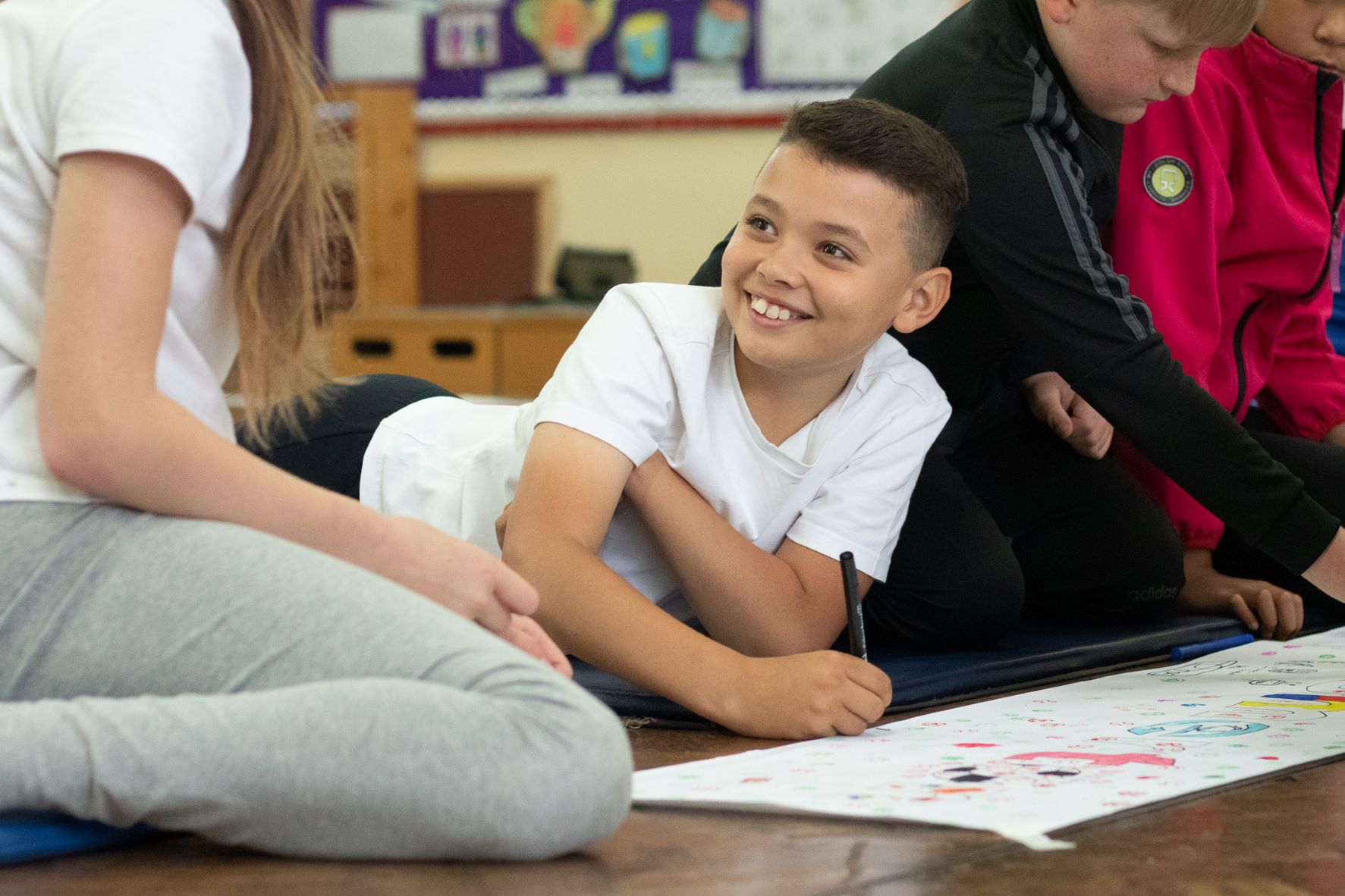 boy smiling while drawing