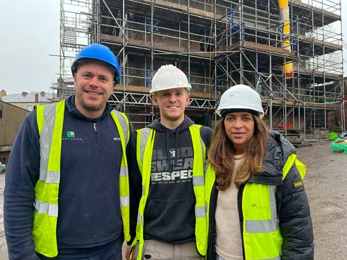 two men and a woman on a building site in hard hats and high viz jackets